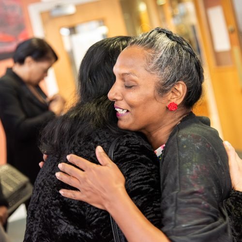 friends embrace with a hug at funeral service