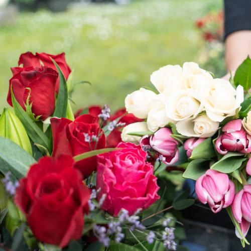 female laying flowers at grave side for funeral